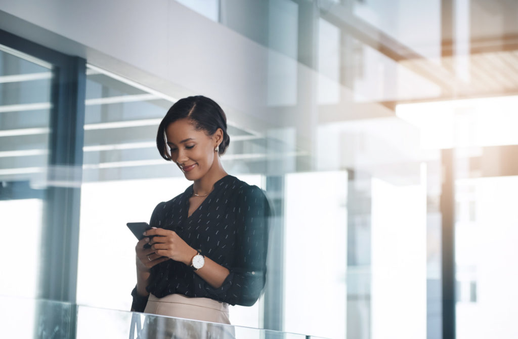 Shot of a young businesswoman using a cellphone in an office