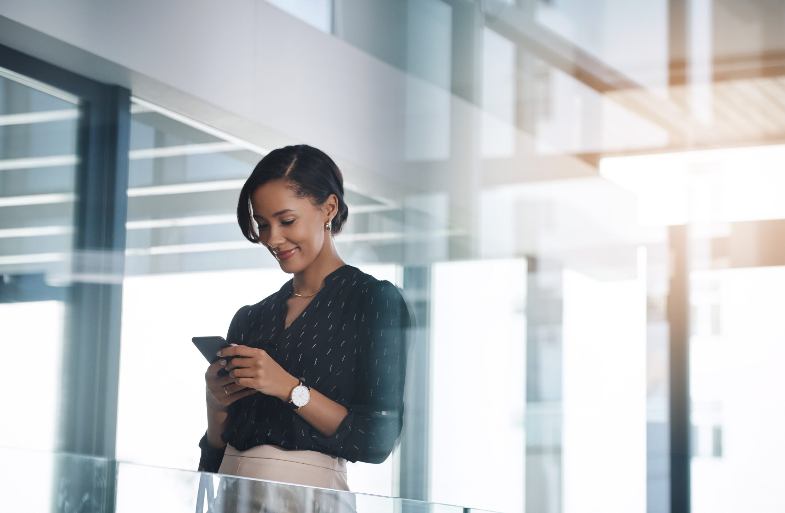 Shot of a young businesswoman using a cellphone in an office